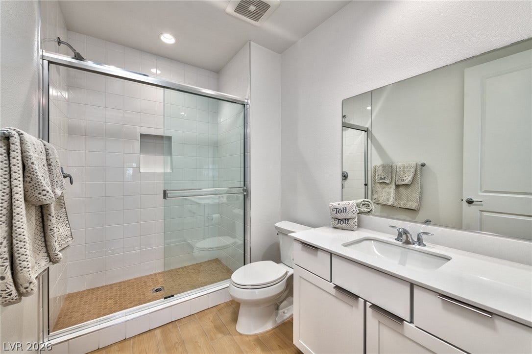 3327 Esker Ridge Avenue, Henderson, NV 89044 A modern bathroom features a glass-enclosed walk-in shower alongside a clean white vanity.