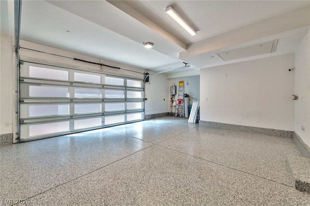 3327 Esker Ridge Avenue, Henderson, NV 89044 Gleaming epoxy floors and a modern frosted-glass door define this spacious garage.
