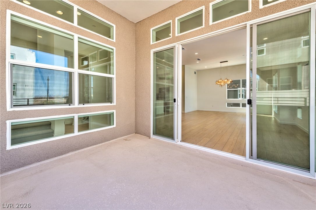 3327 Esker Ridge Avenue, Henderson, NV 89044 Sliding glass doors connect this outdoor patio to the hardwood-floored interior living space.
