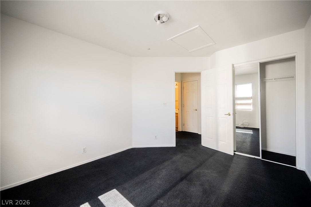 1608 Saddle Rock Circle, Las Vegas, NV 89117 Crisp white walls contrast with dark carpeting in this versatile bedroom space.