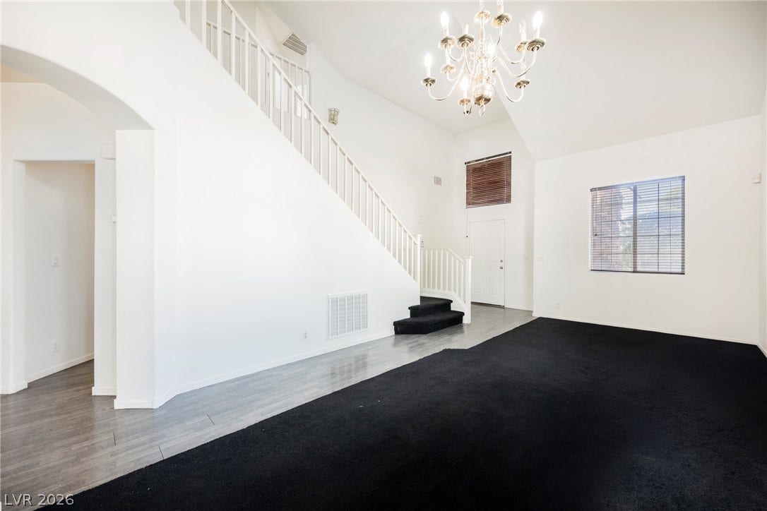 1608 Saddle Rock Circle, Las Vegas, NV 89117 High ceilings and a classic chandelier elevate this light-filled entryway and living space.