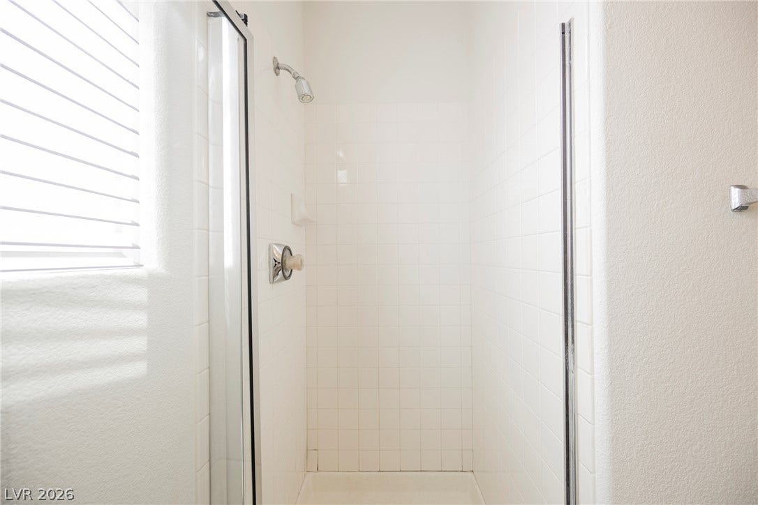 1608 Saddle Rock Circle, Las Vegas, NV 89117 Crisp tiled walls and a glass enclosure define this classic walk-in shower design.