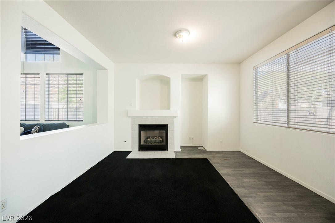 1608 Saddle Rock Circle, Las Vegas, NV 89117 A cozy fireplace anchors this open space accented by dual-texture flooring and large windows.