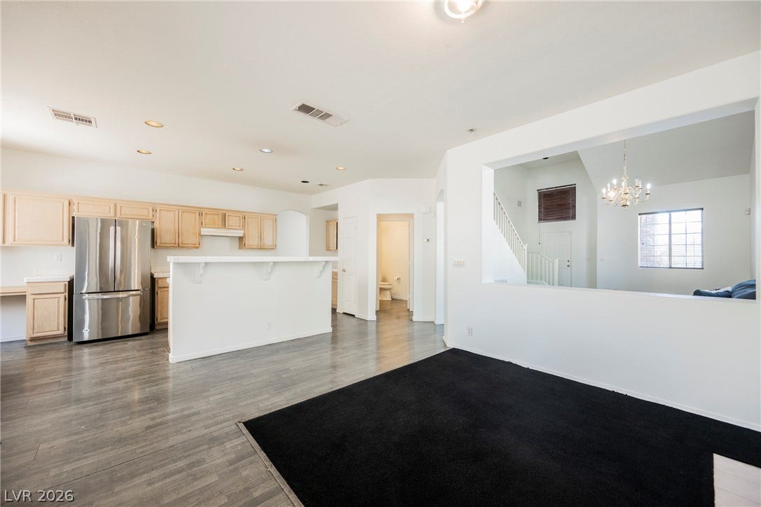 1608 Saddle Rock Circle, Las Vegas, NV 89117 Laminate flooring and a half-wall cutout connect the open kitchen to adjoining living spaces.