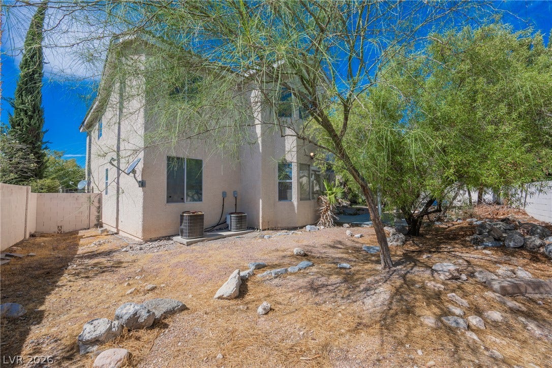 1608 Saddle Rock Circle, Las Vegas, NV 89117 Mature trees frame the stucco exterior and desert landscaping of this two-story residential structure.
