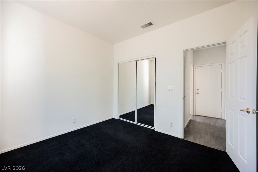 1608 Saddle Rock Circle, Las Vegas, NV 89117 A spacious bedroom features plush dark carpeting and mirrored closet doors.