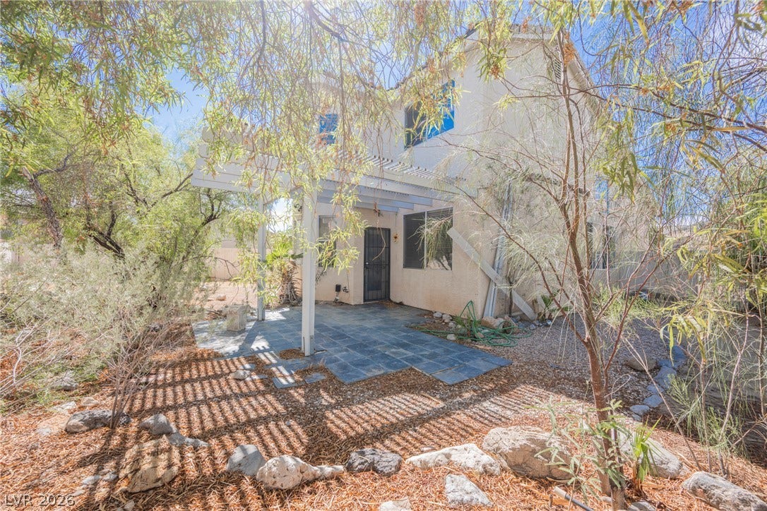 1608 Saddle Rock Circle, Las Vegas, NV 89117 Mature trees shade a tiled patio area behind this multi-story stucco home.