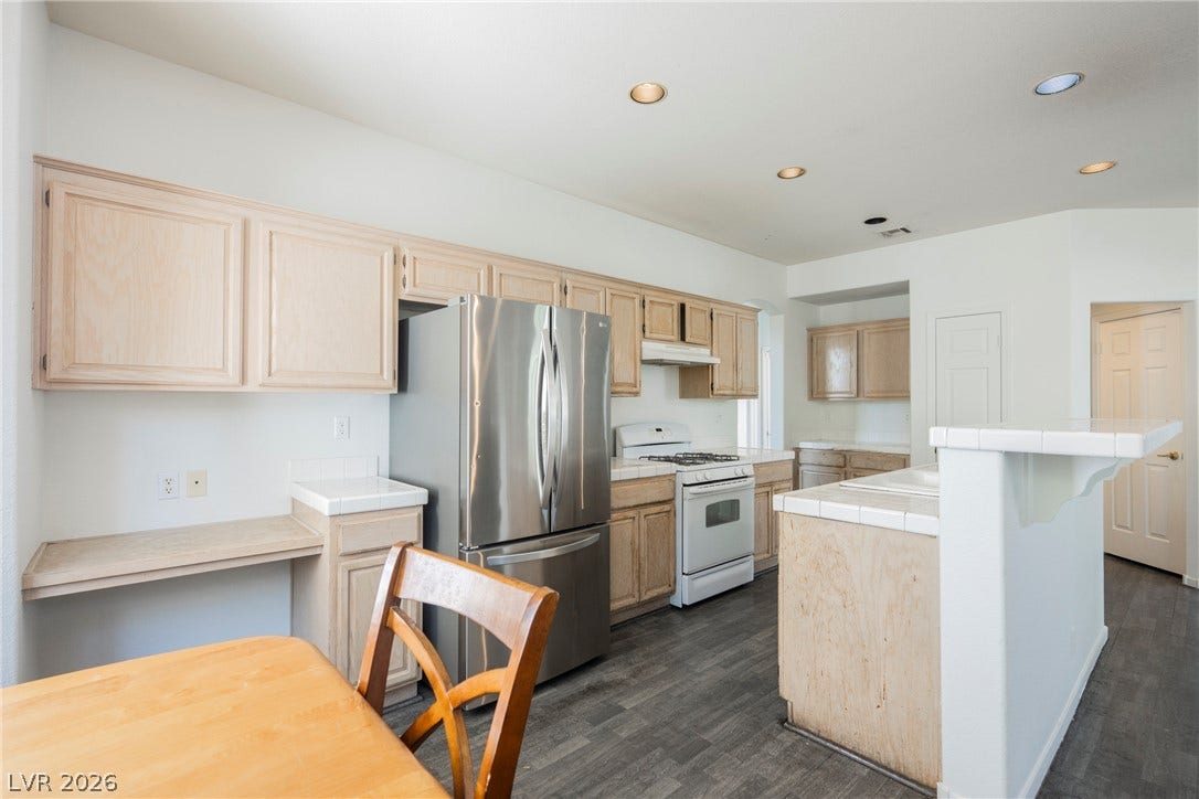 1608 Saddle Rock Circle, Las Vegas, NV 89117 Ample wooden cabinetry and durable tile countertops anchor this functional kitchen layout.