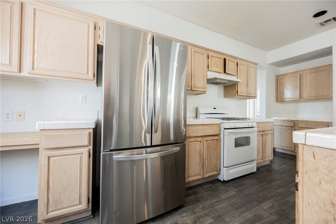 1608 Saddle Rock Circle, Las Vegas, NV 89117 Natural wood cabinetry paired with dark plank flooring defines this functional kitchen space.