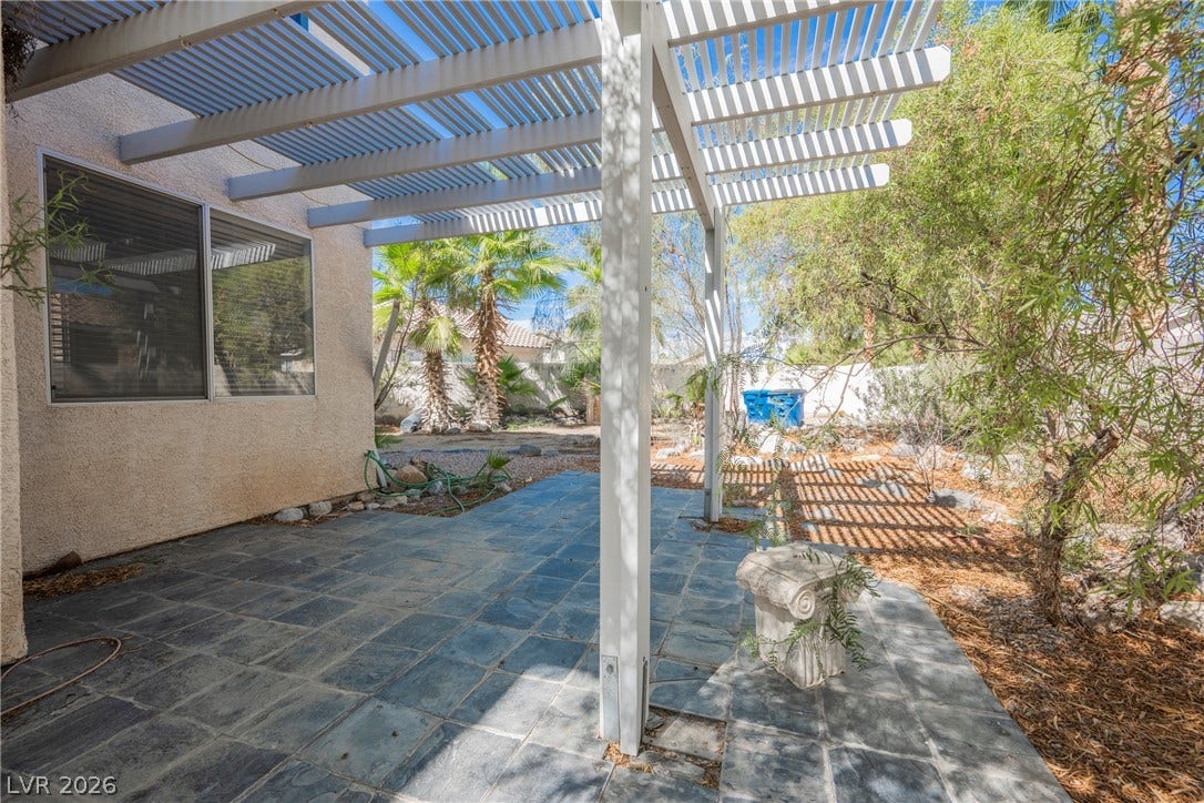 1608 Saddle Rock Circle, Las Vegas, NV 89117 Shaded stone patio provides a quiet outdoor retreat surrounded by mature desert plantings.