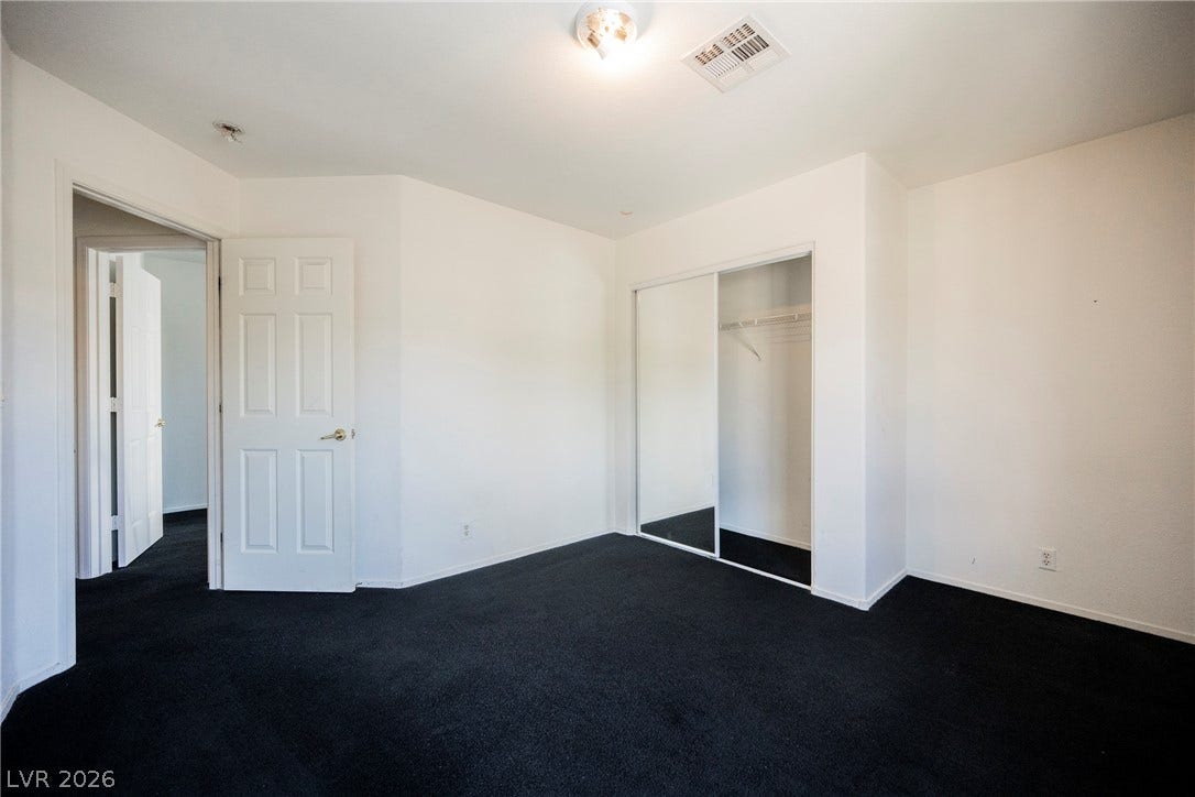 1608 Saddle Rock Circle, Las Vegas, NV 89117 Dark carpeting contrasts cleanly with white walls in this versatile bedroom space.