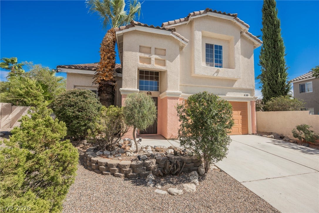 1608 Saddle Rock Circle, Las Vegas, NV 89117 A two-story stucco exterior stands behind drought-tolerant landscaping and a concrete driveway.
