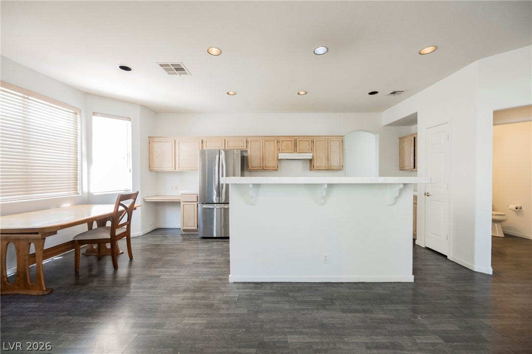 1608 Saddle Rock Circle, Las Vegas, NV 89117 Dark wood-look flooring contrasts beautifully with crisp white walls in this open kitchen space.