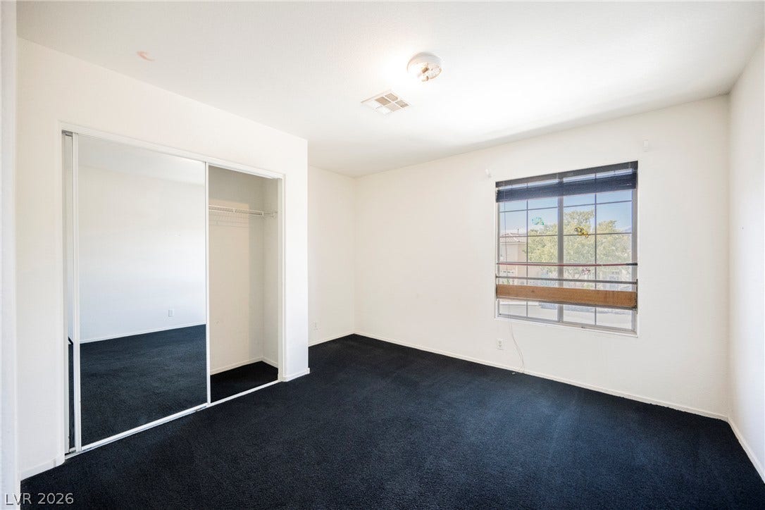 1608 Saddle Rock Circle, Las Vegas, NV 89117 A spacious bedroom displays deep carpeting, a mirrored closet, and a street-facing window.