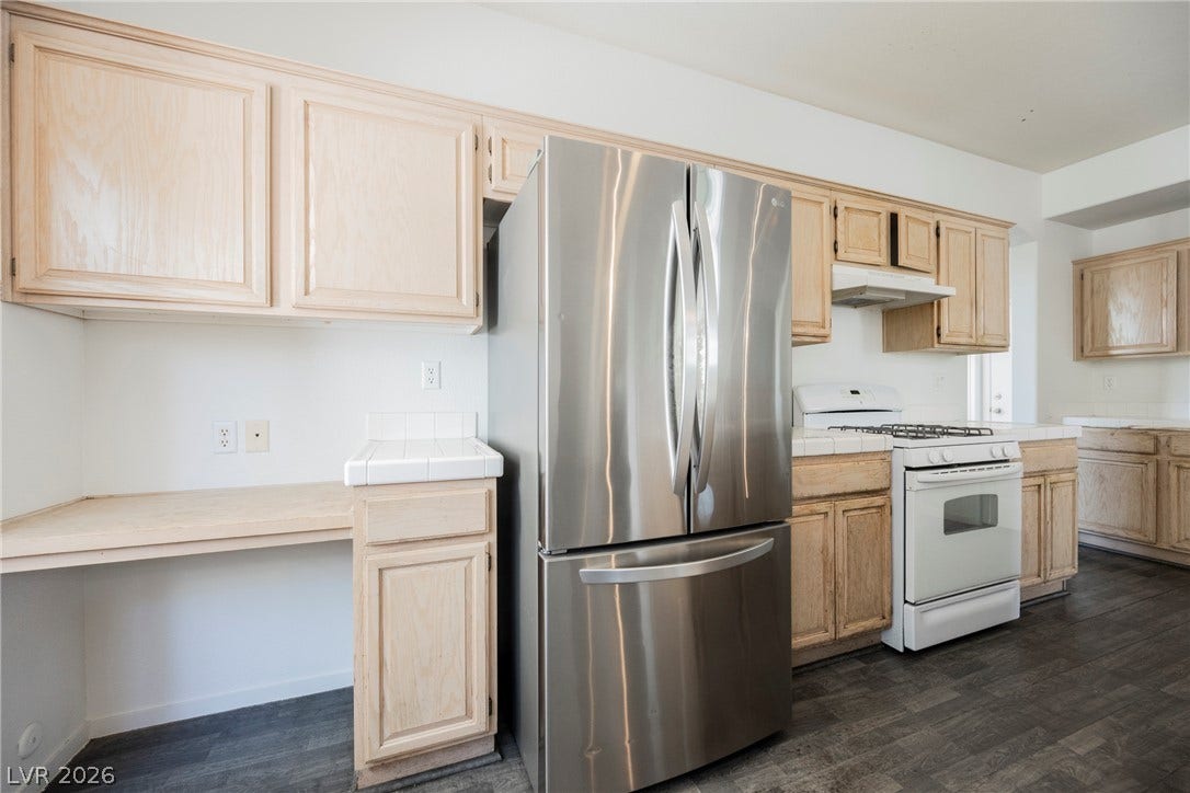 1608 Saddle Rock Circle, Las Vegas, NV 89117 An open kitchen layout balances light wood cabinetry with dark resilient flooring.