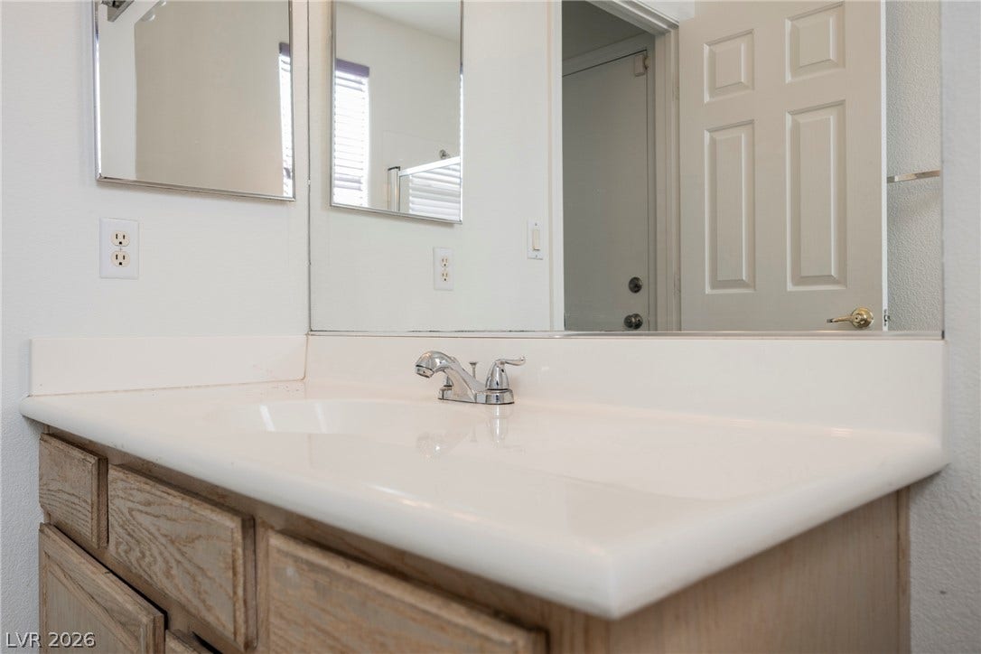 1608 Saddle Rock Circle, Las Vegas, NV 89117 An integrated solid-surface sink and classic oak vanity offer functional style.
