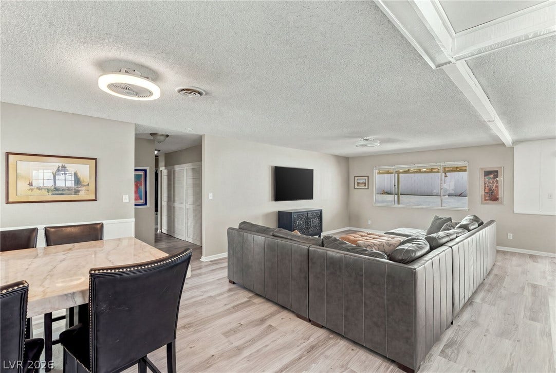 Smooth laminate flooring runs throughout this open dining and living area.