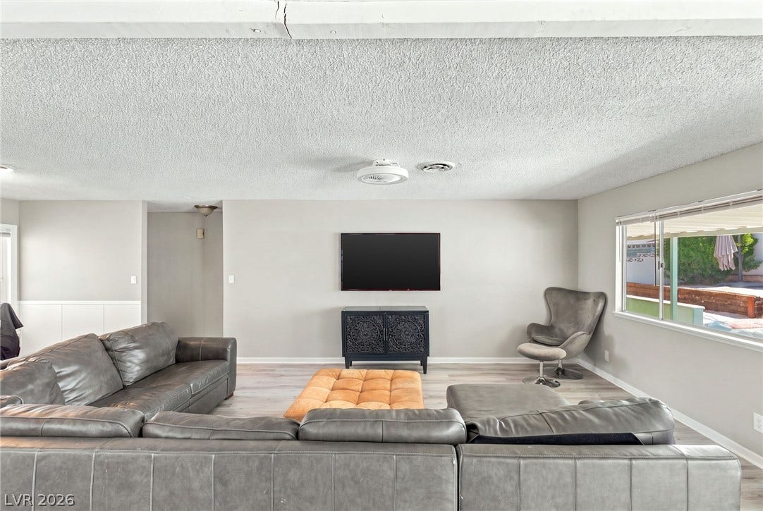 An open layout highlights the wide window overlooking the outdoor patio.
