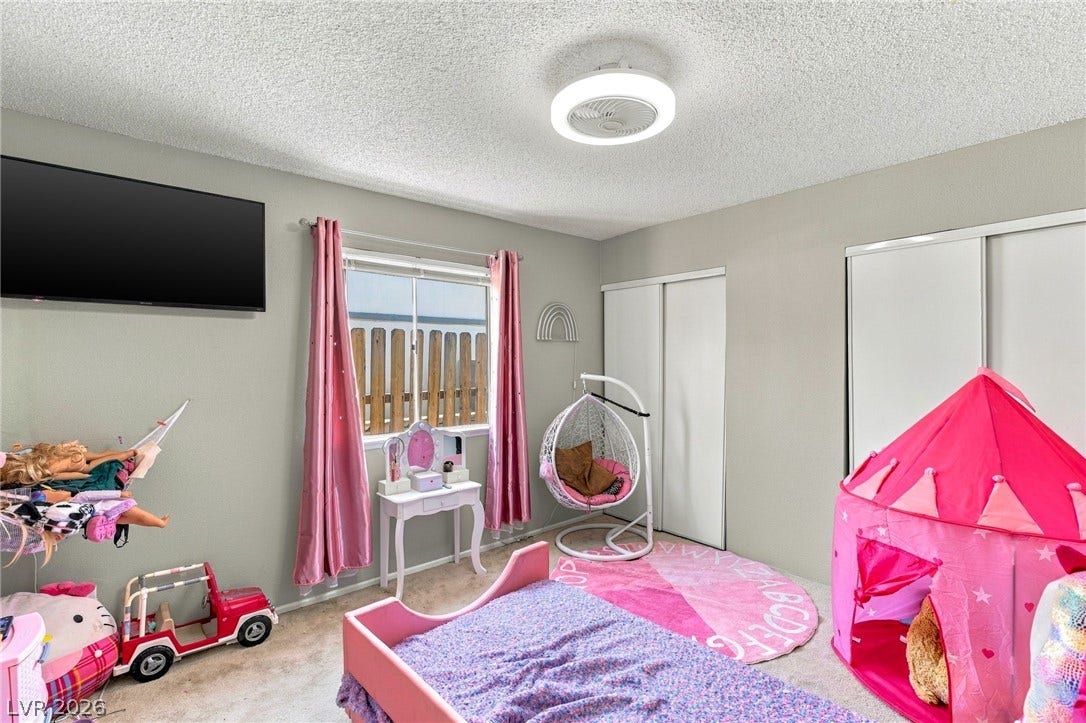 A well-proportioned bedroom features carpet flooring and sliding closet doors.
