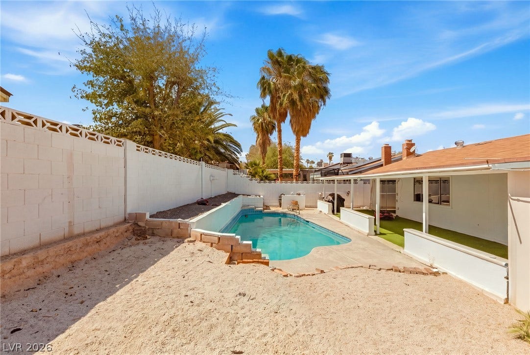 An inviting backyard features a private swimming pool enclosed by secure block walls.