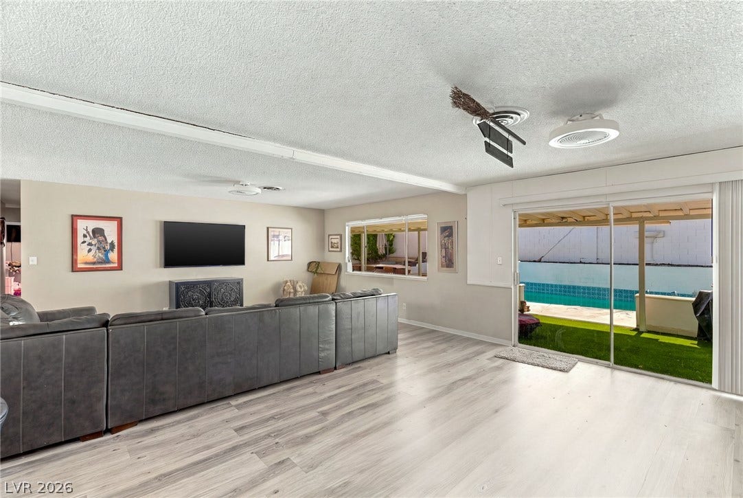 Sliding glass doors open directly to the backyard pool area from this spacious room.
