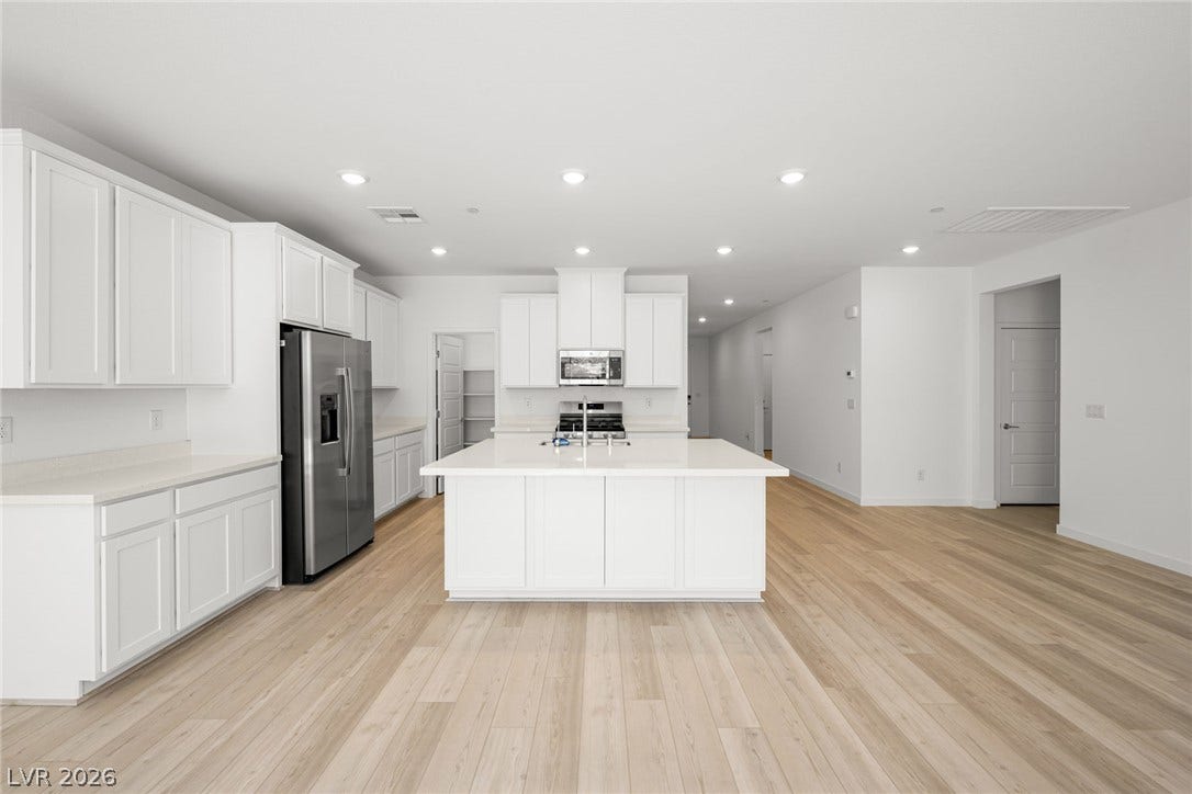 1429 Bianca Falls Drive, Henderson, NV 89011 Gleaming hardwood floors anchor this open-concept culinary space featuring custom cabinetry.