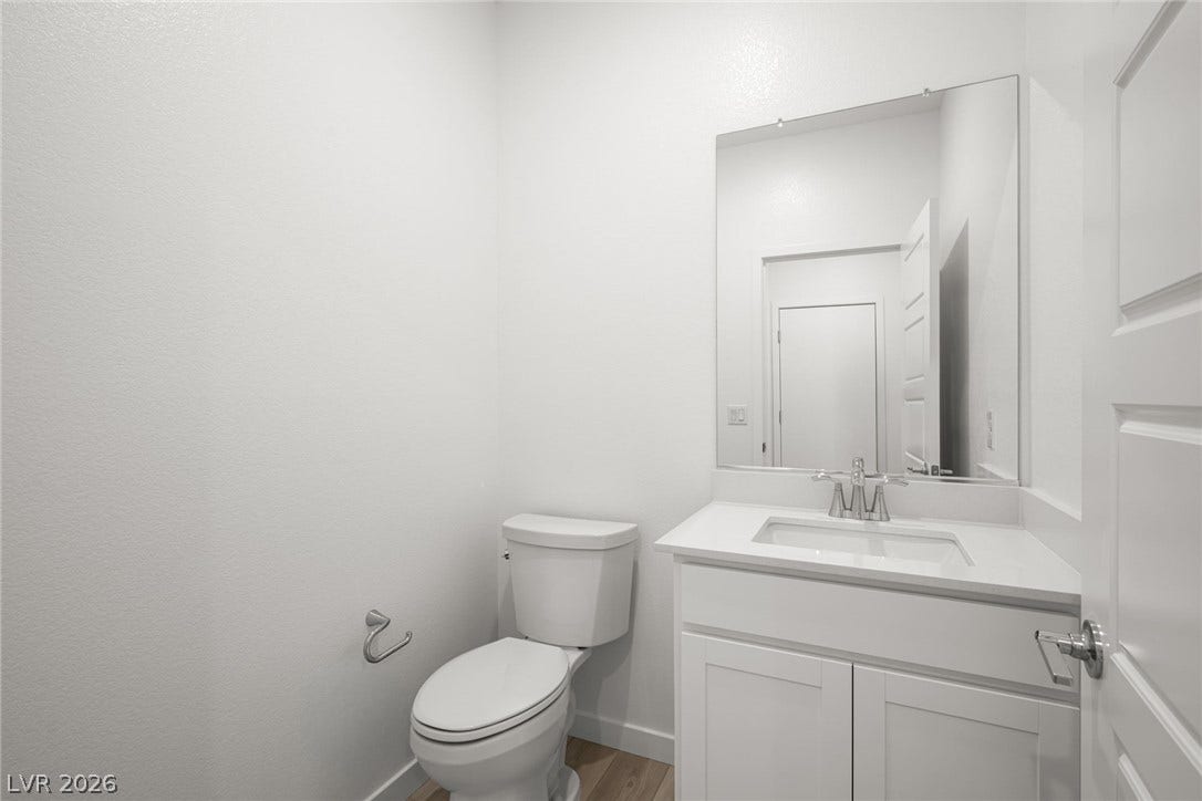 1429 Bianca Falls Drive, Henderson, NV 89011 Clean modern finishes define this sleek powder room featuring a white vanity and crisp walls.