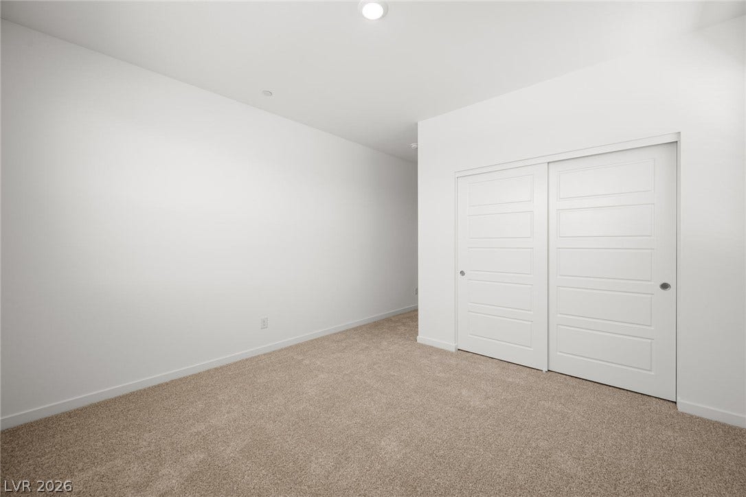 1429 Bianca Falls Drive, Henderson, NV 89011 Plush carpeting and recessed lighting create a comfortable atmosphere in this modern bedroom.
