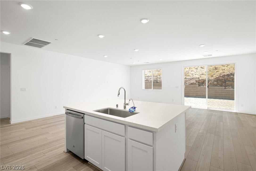 1429 Bianca Falls Drive, Henderson, NV 89011 Gleaming wood floors and recessed lighting illuminate this open-concept kitchen and living area.