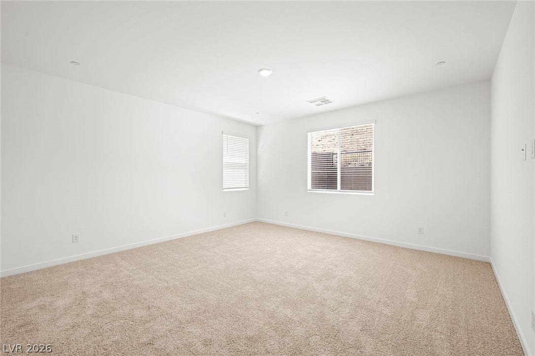 1429 Bianca Falls Drive, Henderson, NV 89011 Plush neutral carpeting and dual windows define this serene and versatile bedroom space.