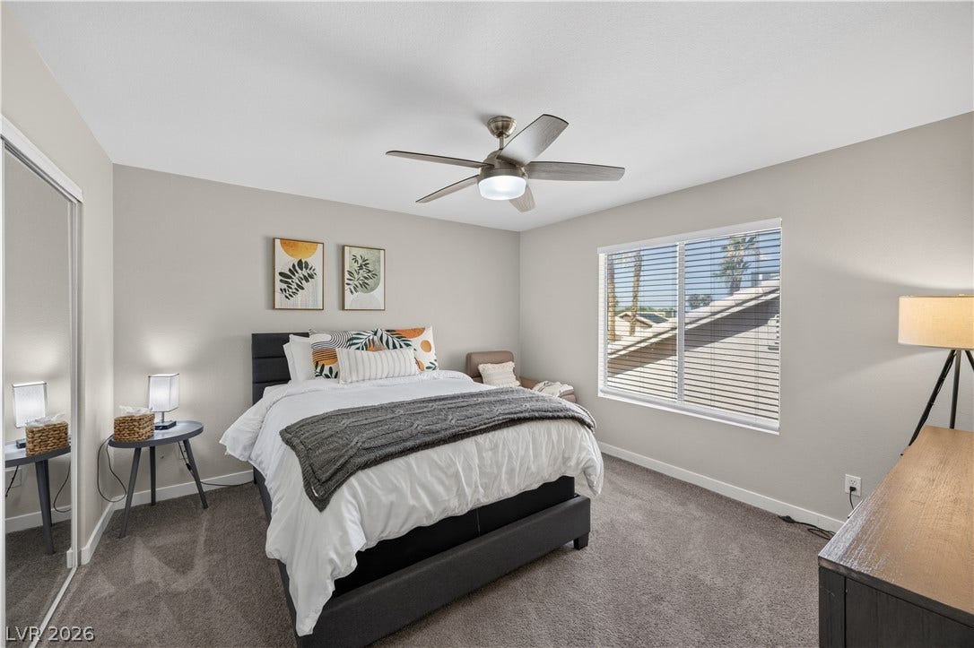 530 Rancho Del Mar Way, North Las Vegas, NV 89031 Natural light pours through a large window, illuminating this comfortable carpeted bedroom.