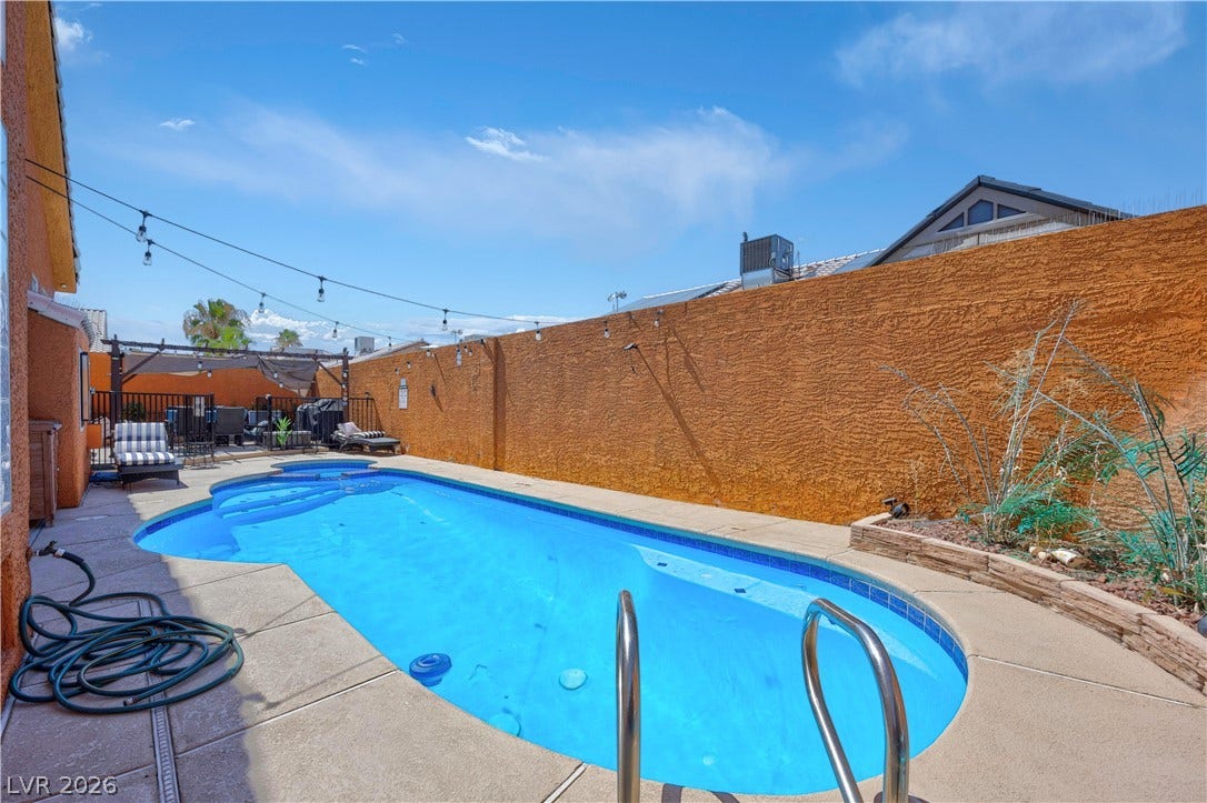 530 Rancho Del Mar Way, North Las Vegas, NV 89031 A private swimming pool is bordered by concrete decking and tall privacy walls.