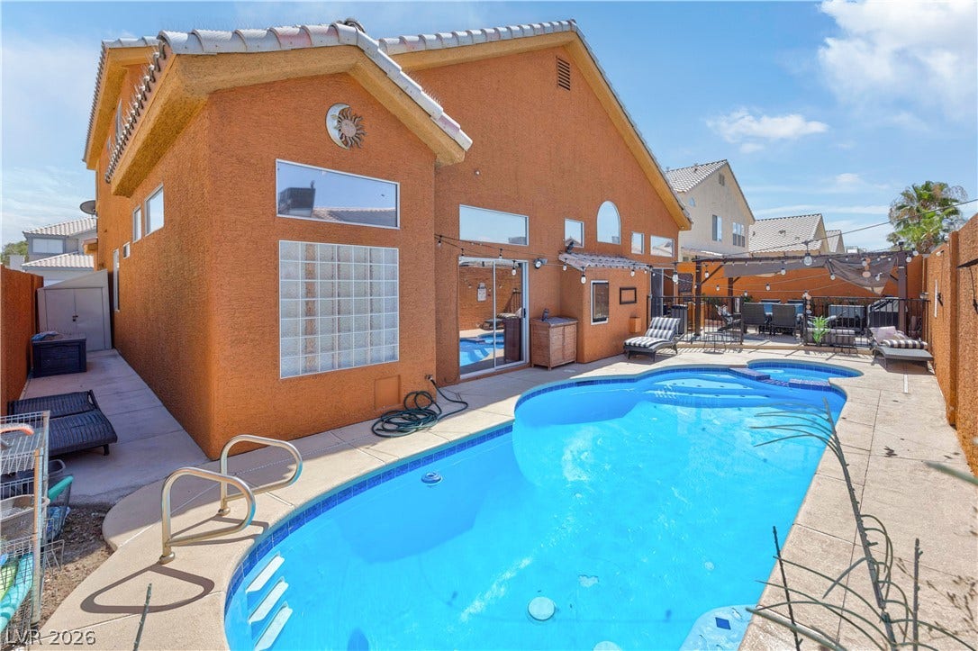 530 Rancho Del Mar Way, North Las Vegas, NV 89031 An inviting backyard oasis centers around a sparkling swimming pool under clear blue skies.