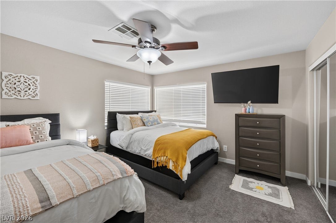 530 Rancho Del Mar Way, North Las Vegas, NV 89031 Plush carpeting anchors this inviting bedroom illuminated by natural light through dual windows.