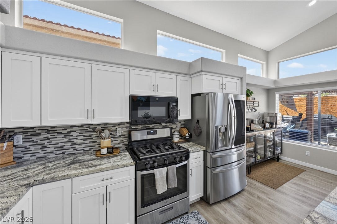 530 Rancho Del Mar Way, North Las Vegas, NV 89031 Gleaming stone countertops and stainless steel appliances elevate this modern kitchen beneath high clerestory windows.