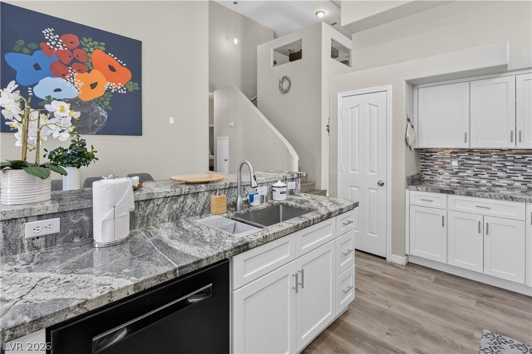 530 Rancho Del Mar Way, North Las Vegas, NV 89031 Gleaming granite countertops pair beautifully with white cabinetry and modern flooring in this multi-level space.