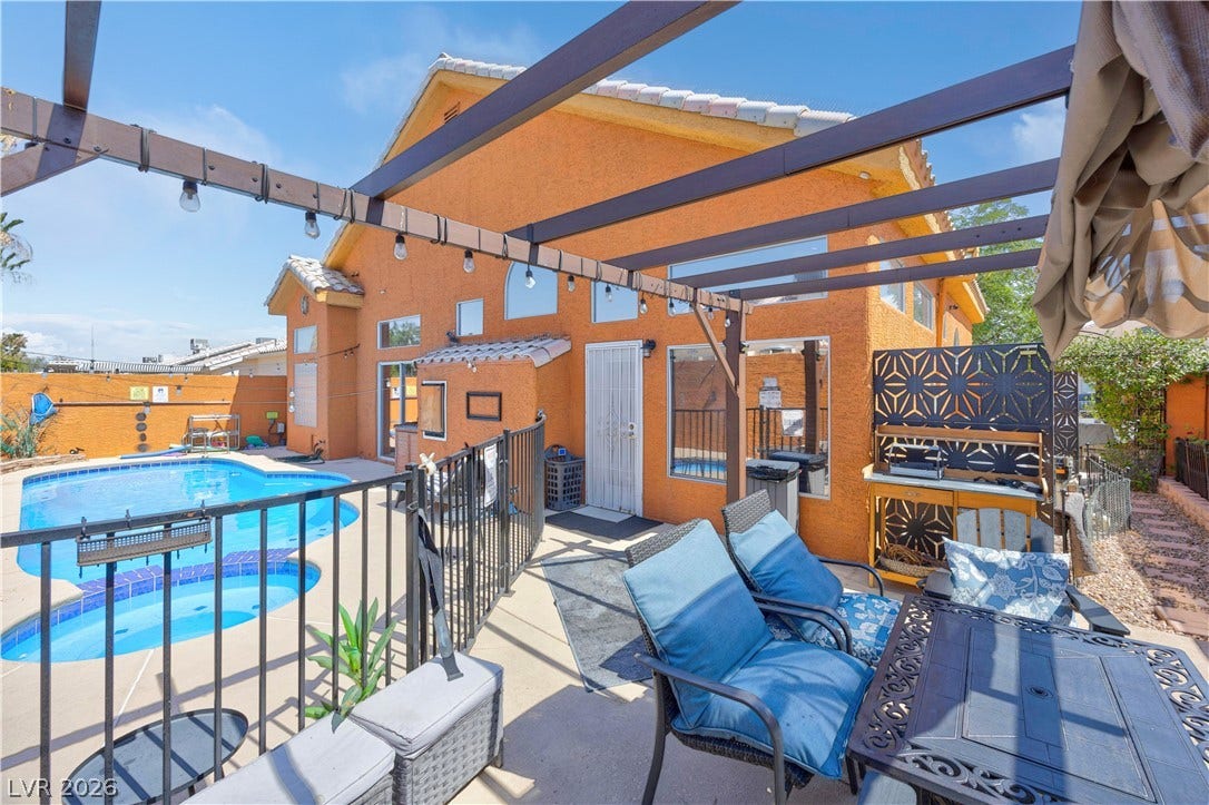 530 Rancho Del Mar Way, North Las Vegas, NV 89031 An inviting backyard oasis features a built-in swimming pool and a shaded pergola structure.