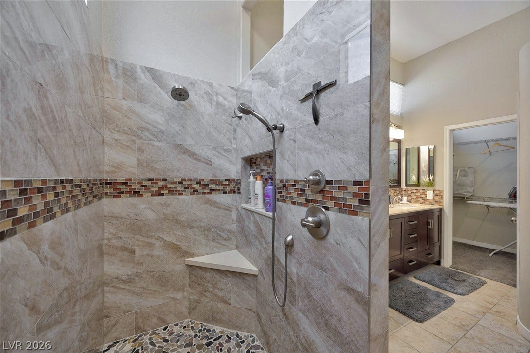 530 Rancho Del Mar Way, North Las Vegas, NV 89031 Fine tilework and a pebble floor define this walk-in shower adjacent to the main vanity.