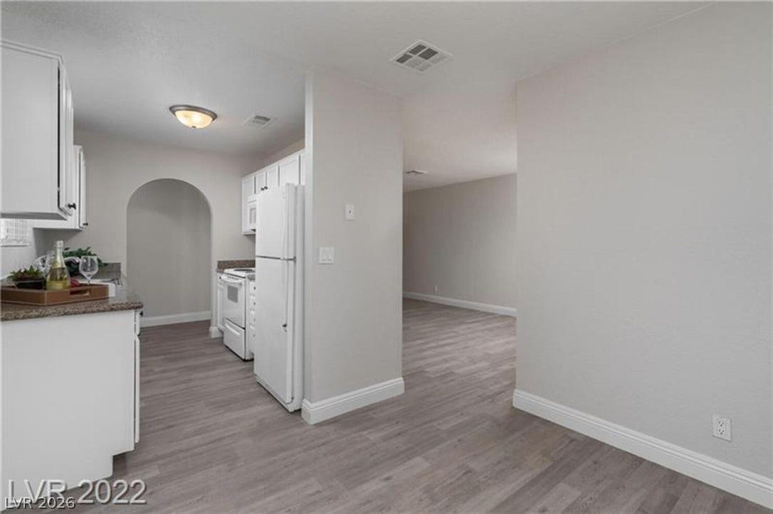 1814 N Decatur Boulevard, #202, Las Vegas, NV 89108 An open doorway leads from the kitchen into a spacious dining area with wood-look flooring.