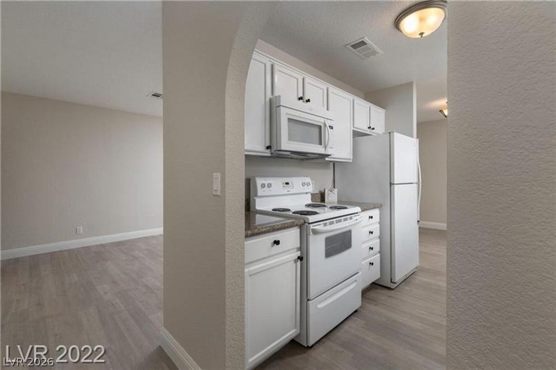 1814 N Decatur Boulevard, #202, Las Vegas, NV 89108 An arched doorway leads into a kitchen featuring solid countertops and modern flooring.