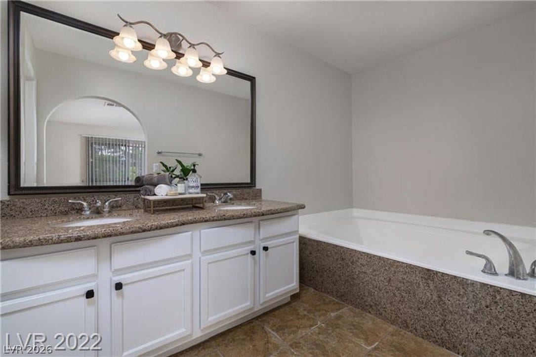 1814 N Decatur Boulevard, #202, Las Vegas, NV 89108 Stone counters highlight the dual vanity and matching soaking tub deck in this bathroom.