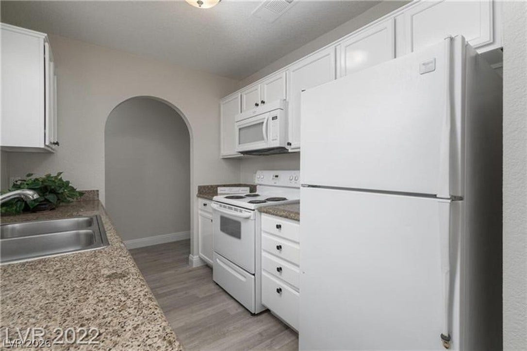1814 N Decatur Boulevard, #202, Las Vegas, NV 89108 An arched doorway connects this updated galley kitchen to the adjacent living spaces.