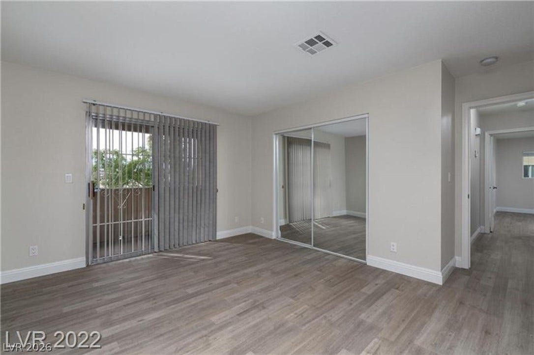 1814 N Decatur Boulevard, #202, Las Vegas, NV 89108 Sliding doors open to a private balcony, illuminating the durable plank flooring.