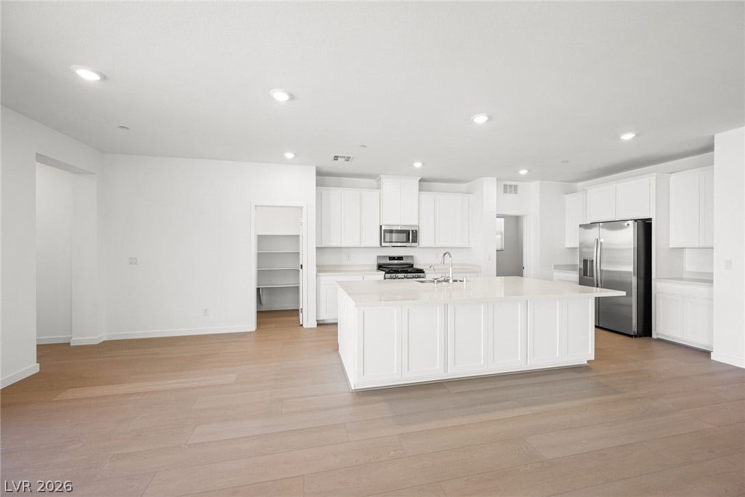 1480 Bianca Falls Drive, Henderson, NV 89011 An expansive kitchen layout boasts seamless transition to the adjacent living spaces over hardwood flooring.