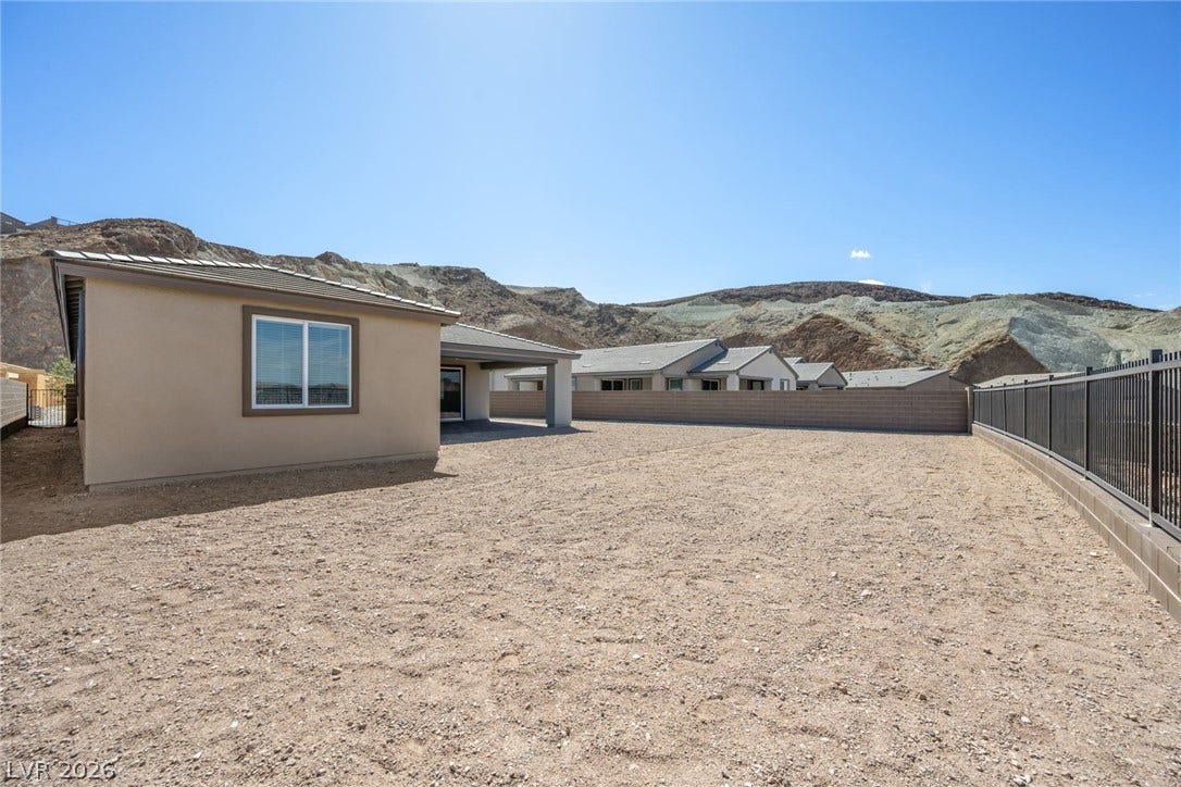 1480 Bianca Falls Drive, Henderson, NV 89011 An expansive backyard space bordered by fencing sits against a dramatic mountain backdrop.
