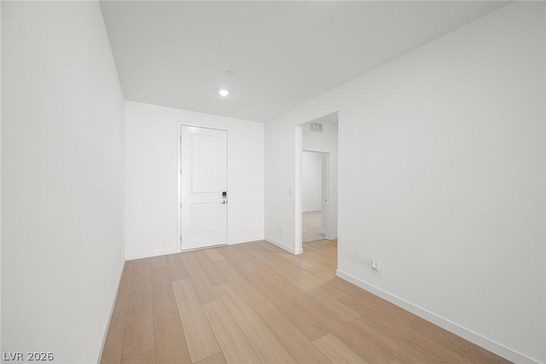 1480 Bianca Falls Drive, Henderson, NV 89011 Gleaming hardwood floors run through a minimalist entryway with smooth plaster walls and recessed lighting.