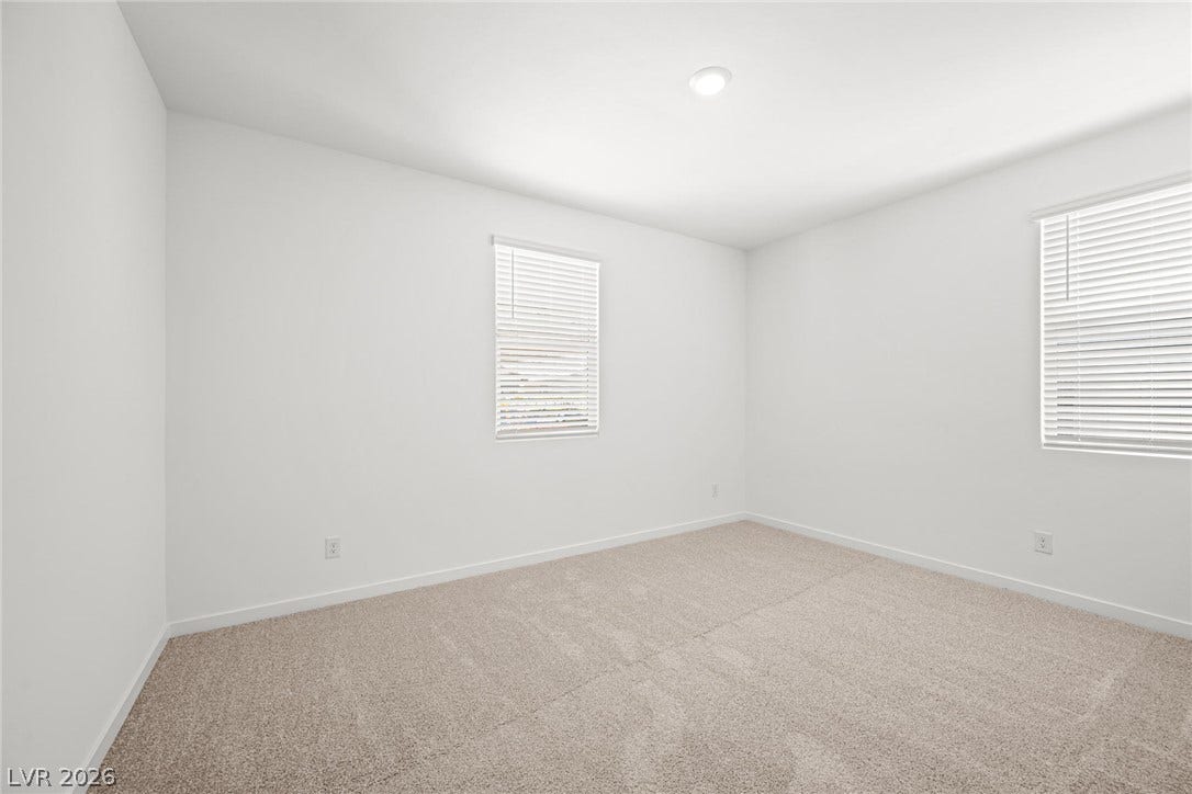 1480 Bianca Falls Drive, Henderson, NV 89011 Crisp white walls and plush carpeting define this versatile secondary bedroom space.