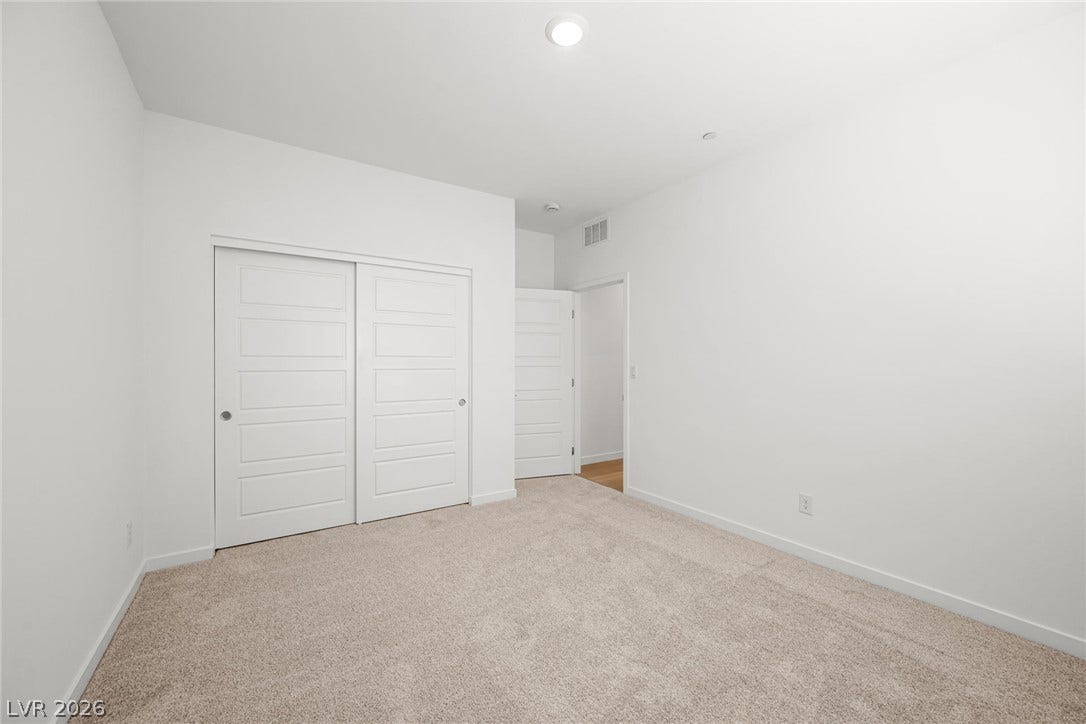 1480 Bianca Falls Drive, Henderson, NV 89011 Plush wall-to-wall carpeting and clean white walls define this comfortable bedroom space.
