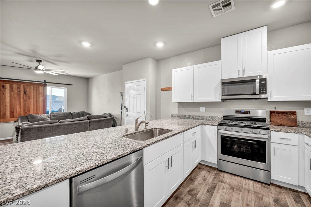 Granite countertops and white cabinetry anchor this open modern kitchen space.