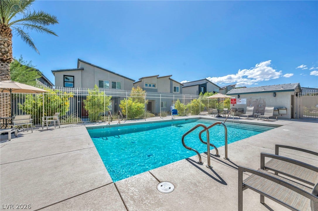 An inviting swimming pool is surrounded by concrete decking and secured with protective fencing.